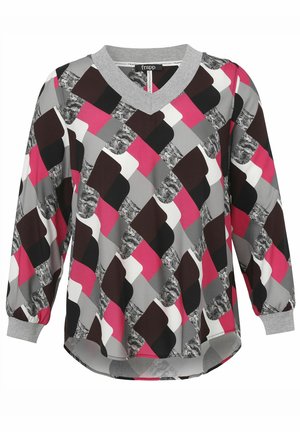 Blouse multicolore avec un col en V, des manches longues et un motif géométrique en rose, noir, gris et blanc. Tissu doux avec une texture lisse.