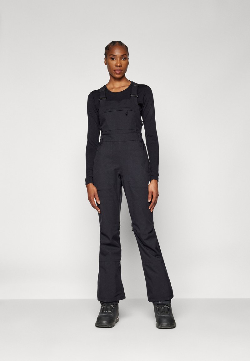 Black overalls made from durable fabric, featuring adjustable straps, a front pocket, and slim-fit legs with zippers at the ankles.