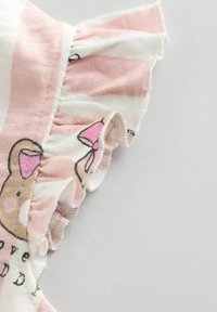 Tissu en coton léger rayé rose et blanc, avec des bords froncés et un imprimé d'ours agrémenté d'un nœud rose.