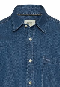 Blaues Hemd mit Knöpfen aus strukturiertem Stoff und kleiner Brusttasche. Hat einen klassischen Kragen und weiße Knöpfe, mit sichtbarem Markenlabel.