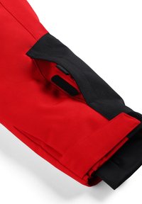 Red and black fabric sleeve with a textured finish and Velcro closure. The design features a fold with exposed stitching and accents.