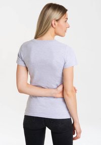 Gray short-sleeve T-shirt made of cotton blend. Features a crew neckline and a slim fit. Worn with black jeans, view from the back.