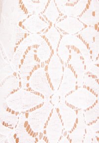 Tissu en dentelle blanche avec un motif floral et géométrique complexe montrant un travail de fil détaillé et des sections transparentes.