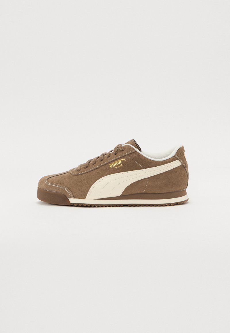 Braune Wildleder-Sneaker mit einem weißen Lederstreifen an der Seite, runder Zehenpartie, goldenem Logo an der Seite und einer strukturierten Gummisohle.