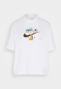 Vit Nike Air t-shirt med en 3D-liknande Nike-logotyp som har en gyllene björngrafik och en abstrakt oval bakgrund på bröstet.