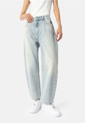 Lyseblå denimjeans med avslappet passform, høyt liv, fem lommer og en subtil falmet finish. Sammen med hvite joggesko.