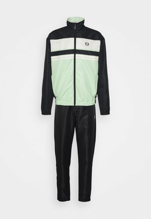 Sportovní souprava s designem mátově zelené a černé barvy. Bunda má vysoký límec, zapínání na zip a horizontální bílé pruhy. Kalhoty jsou černé.