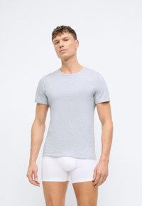 Grå t-skjorte med kort erme laget av myk stoff, med rund halslinning og en tettsittende design, parret med hvite tettsittende boxershorts.