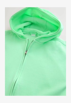 Miętowa zielona bluza z kapturem na suwak z prążkowaną podszewką wewnętrzną, metalowym zamkiem błyskawicznym i miękką teksturą. Posiada duży, regulowany kaptur.