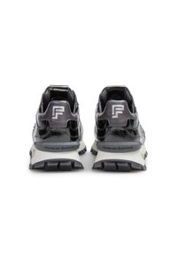 Svarta patentläders sportskor med en texturerad finish, med en tjock vit mellansula och svart mönstrad sula. Silverfärgad logotypdetalj på hälen.