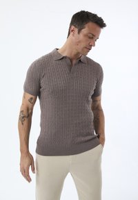 Kortærmet polo skjorte i lys brun ribstrikket stof med kabelmønstre, der har en klassisk krave og tre knapper. Slim fit-design.