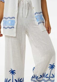 Witte linnen broek met een blauw palmbomenprint aan dezoom. Losse pasvorm met een textuurstof en een verstelbare tailleband.