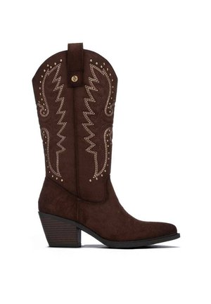 Bota de vaquero marrón oscuro con costuras blancas decorativas, tachuelas doradas, una presilla y un tacón grueso en bloque.