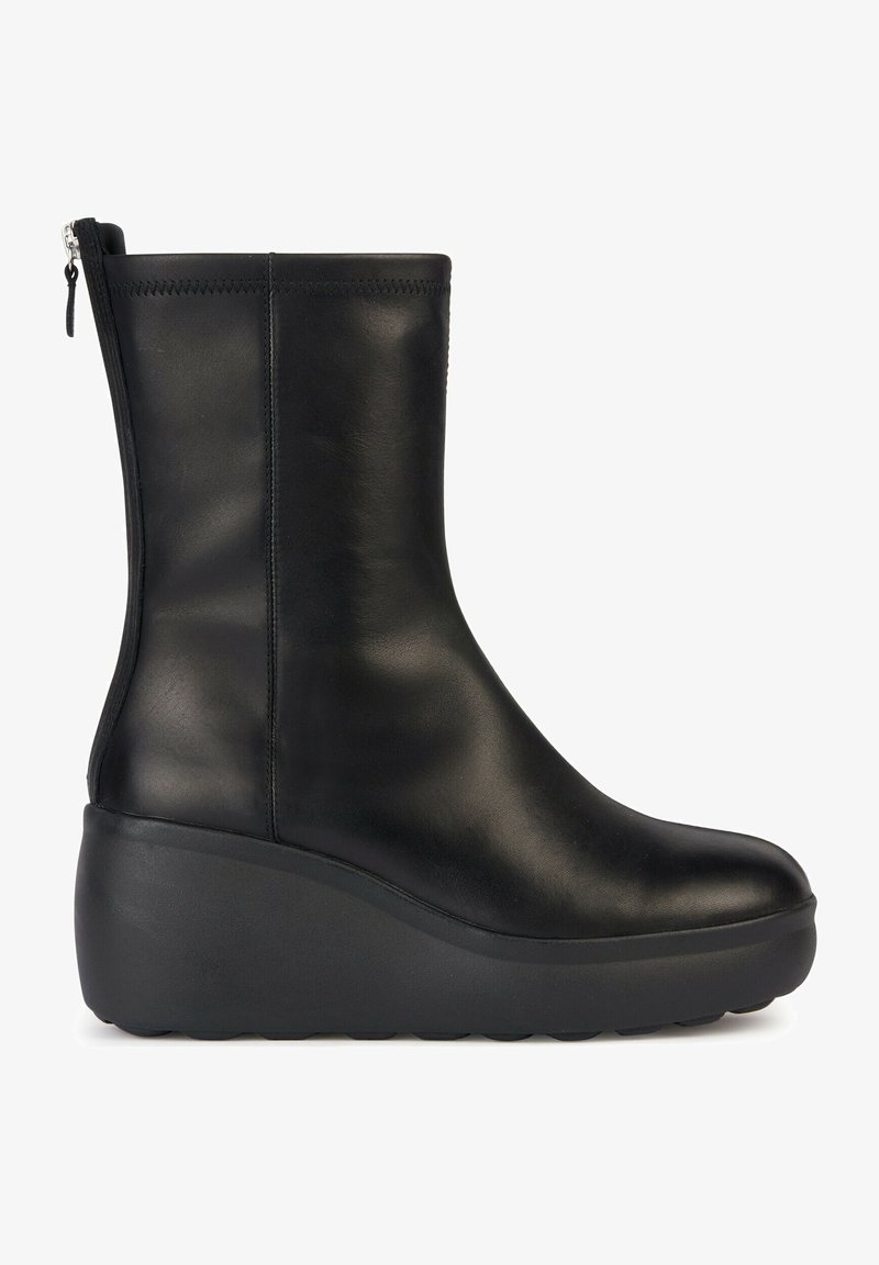 Bottine en cuir noir avec bout arrondi, semelle épaisse à plateforme et fermeture éclair à l’arrière.