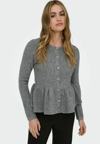 Sivi pleteni kardigan s peplum pasom, prednjim gumbom i dugim rukavima; meka tekstura i rebrasti dizajn povećavaju vizualni interes.