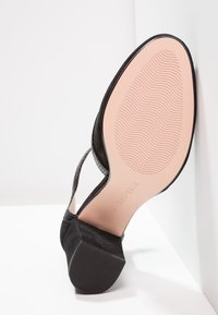 Černá semišová lodička na vysokém podpatku s texturovanými pásky, hladkou růžovou stélkou a vroubkovanou gumovou podrážkou pro lepší přilnavost.