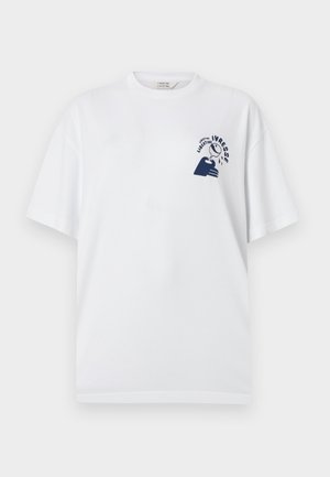 Maglietta bianca a maniche corte con grafica blu navy di una mano che tiene un bicchiere che gocciola e testo "Ivresse Libertine" sul petto in alto a sinistra.