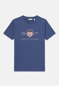 Blå bomulls T-skjorte med rund hals, med trykt logo og skjolddesign i rødt og hvitt med teksten "1949" og "AMERICAN SPORTSWEAR".