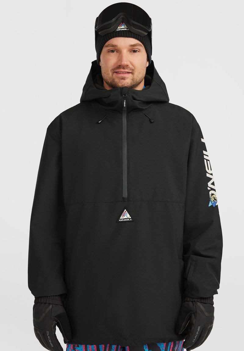 Zwarte pullover jacket met capuchon, voorzien van een voorkant rits en een driehoekig logo. Vergezeld van zwarte handschoenen en gebloemde broek.