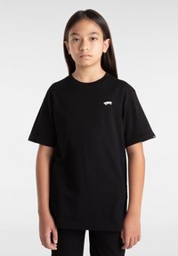 Černé bavlněné tričko s malou bílou grafikou skateboardu na levé části hrudi, krátké rukávy a volný střih.