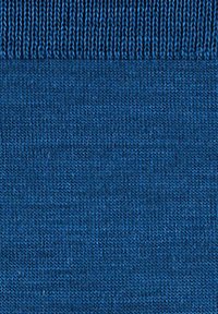 Blauwe gebreide stof met twee verschillende steekpatronen: geribd bovenaan en glad tricot onderaan.