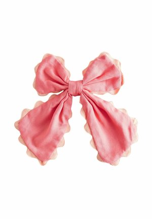 Rosa Stoffschleife mit wellenförmigen Kanten, locker in einem doppelten Schlaufenstil gebunden auf weißem Hintergrund.