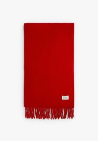 Manta de lana roja con flecos en la parte inferior y una pequeña etiqueta en un lado. Textura suave, forma rectangular.