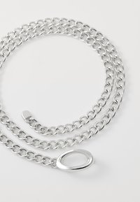 Zilverkleurige metalen ketting met een ovale schakelontwerp, voorzien van een gladde textuur en een centrale ovale sluitingdetail.