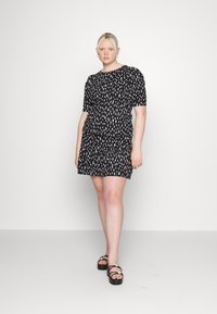 Vestido preto curto com um corte solto, apresentando padrões abstratos brancos, mangas curtas e uma textura franzida na cintura.