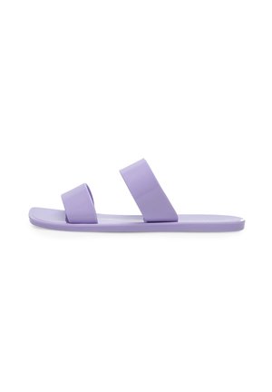 Płaska lawendowa sandałka na płaskiej podeszwie z dwoma szerokimi paskami na stopie, jednym przy palcach, a drugim przy śródstopiu, na białym tle.