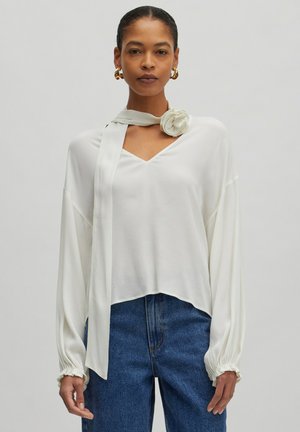 Weiße Bluse mit V-Ausschnitt, langen Ärmeln und gerafften Manschetten. Enthält einen passenden Schal, der am Hals mit einem Rosenmotiv gebunden wird.