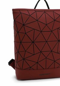 Raudona geometrinė rankinė su tekstūruotu paviršiumi, kuriame yra juodų trikampių raštas ir viršutinė rankena. Logotipas pateiktas dugne.