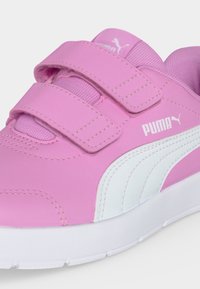 Ροζ αθλητικό παπούτσι Puma με λευκή γραμμή, δύο λουράκια βέλκρο και επενδεδυμένη λευκή σόλα.