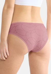 Roze katoenen slipjes met een geprint ontwerp en kantafwerking. Kenmerkt zich door een zachte textuur en een middelhoge snit, die subtiele gebogen lijnen toont.