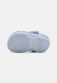 Niebieskie klapki z brokatem z teksturowaną, żłobioną gumową podeszwą. Regulowany pasek zapewniający pewne dopasowanie. Gładkie wykończenie podkreśla ogólną trwałość.