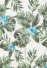 Bloemtextiel met grote groene bladeren en blauwe bloemen op een witte achtergrond, met een zachte textuur en levendige kleuren.