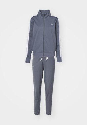 Gray athletic tracksuit made of soft fabric. Features a zip-up jacket with a high collar and white side stripes, paired with tapered pants.