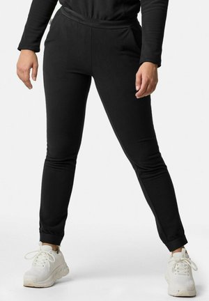 Czarne tapered joggery z teksturowanej tkaniny, z elastycznym pasem i bocznymi kieszeniami, zestawione z białymi sportowymi trampkami.