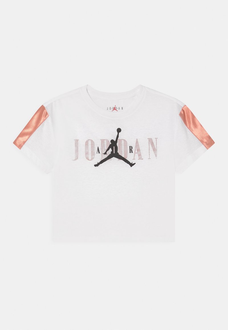 Biała, skrócona koszulka Jordan z czarnym logo Jumpman, wybledłym napisem "JORDAN" oraz błyszczącymi pomarańczowymi paskami na rękawach.