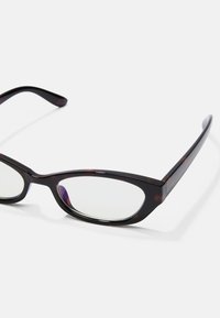 Cat-Eye-Brillen mit dunklem Schildpatt-Rahmen, dünnen Bügeln und klaren Gläsern. Besitzt ein elegantes Design mit einer markanten Form und glatter Oberfläche.