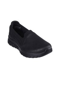 Czarne buty wsuwane z elastycznej tkaniny, charakteryzujące się bezszwowym wzornictwem, zaokrąglonym noskiem oraz teksturowaną gumową podeszwą zapewniającą przyczepność i elastyczność.