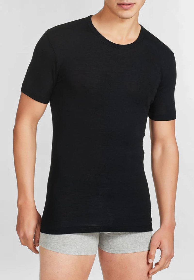 T-shirt nero a maniche corte con scollo rotondo, realizzato in tessuto leggero. La trama appare liscia; il design aderente esalta la forma del corpo.
