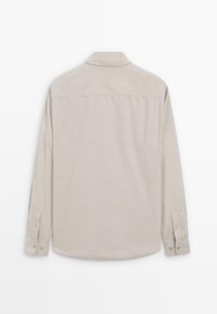 Camicia a maniche lunghe in tessuto beige chiaro con una consistenza morbida. Presenta un colletto classico e polsini con bottoni. Superficie posteriore liscia.