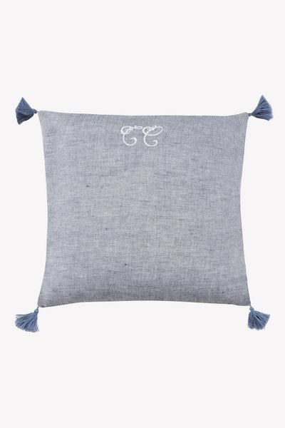 Μπλε υφαντό μαξιλάρι με διακοσμητικές φούντες σε κάθε γωνία, με κεντητό σχέδιο σε ανοιχτότερο μπλε χρώμα. Ομαλή υφή.