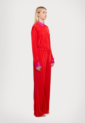 Costum roșu din mătase, cu mâneci lungi, deschidere cu butoane în față și guler roz. Include o talie elastică și un design cu picioare largi pentru o potrivire relaxată.