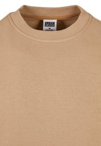 Beige Sweatshirt mit geripptem Rundhalsausschnitt und strukturiertem Stoff. Etikett mit der Aufschrift "URBAN CLASSICS", Größe Medium.
