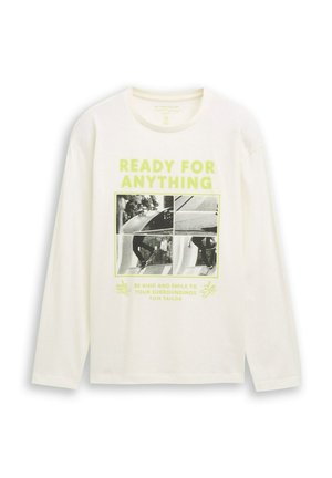 Chemise blanche à manches longues avec le texte néon "PRÊT POUR TOUT" et une grille de photos de skate noir et blanc sur le devant.