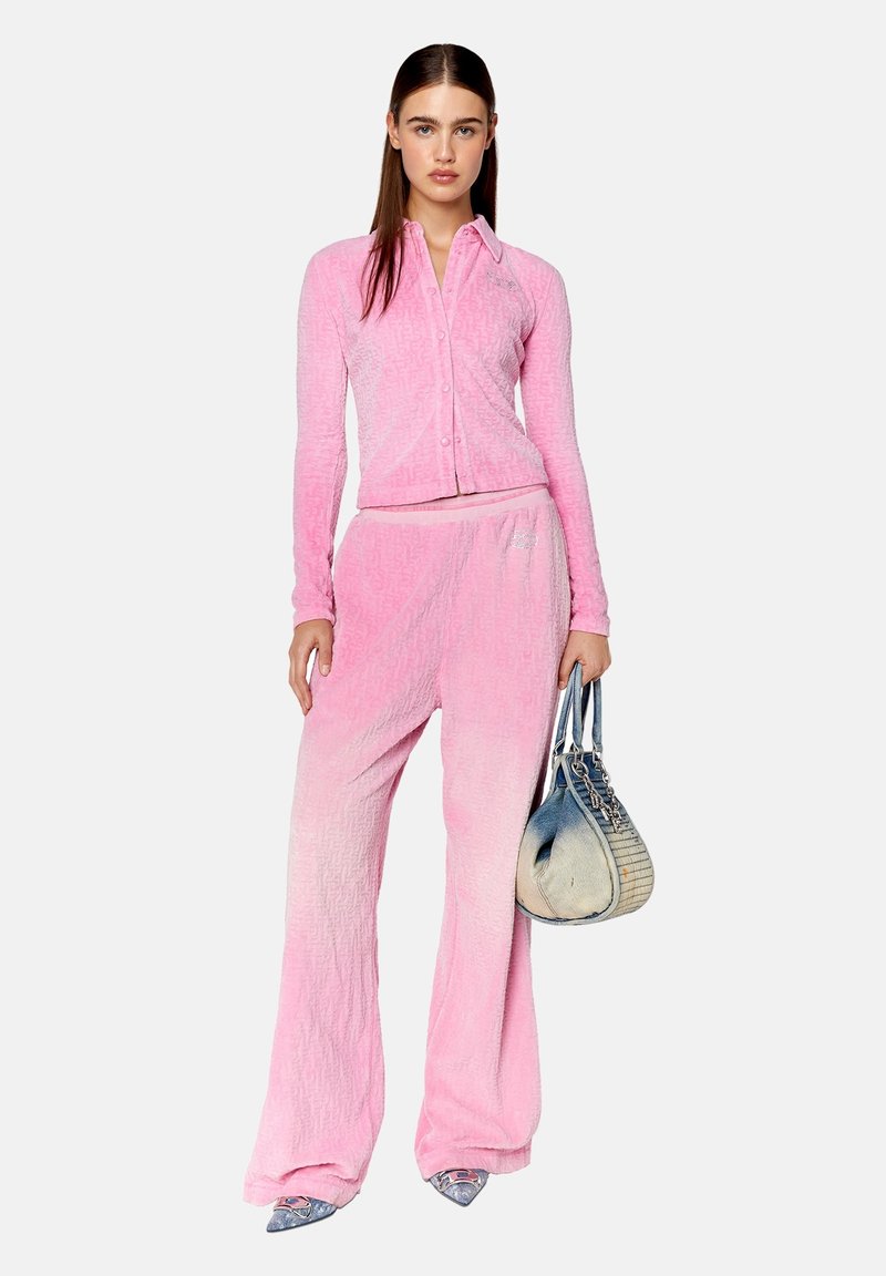 Ensemble deux pièces texturé rose, comprenant un haut ajusté à boutonner et un pantalon large. Un effet dégradé passe du rose clair au rose foncé.