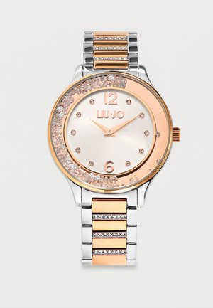 Montre ronde en argent et or rose avec accents en cristal, index des heures en or rose et bracelet à maillons métallique bicolore.