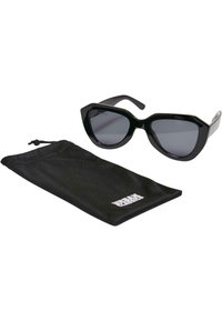 Ochelari de soare negri cu formă cat-eye, lentile închise la culoare, cadru lucios și accente argintii, însoțiți de un pachet din material textil negru cu logo alb.
